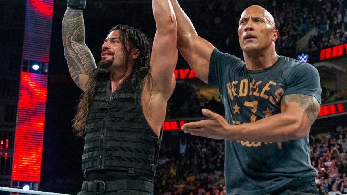 The Rock celebrating with a victorious Roman Reigns after his Royal Rumble win