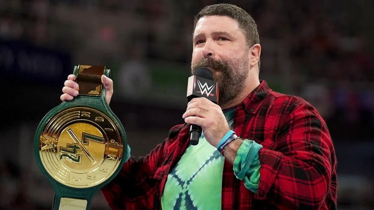 Mick Foley holding the WWE 24/7 Championship in the ring on Raw