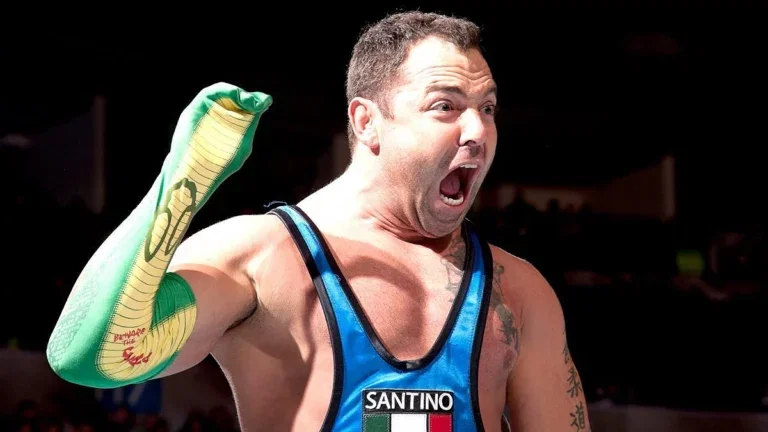 Santino Marella with a snake sock puppet on his arm preparing to hit his finishing move 'The Cobra'