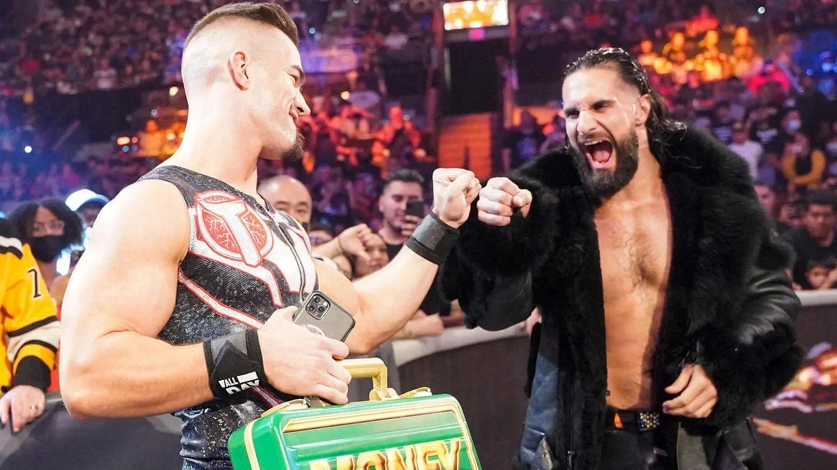 Theory holding his Money in the Bank briefcase gives Seth Rollins a fist bump