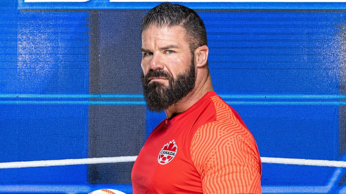 Robert Roode in front of the SmackDown backdrop for the WWE World Cup photoshoot