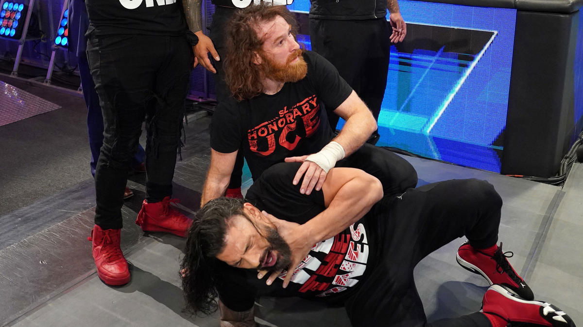 Sami Zayn helping a downed Roman Reigns