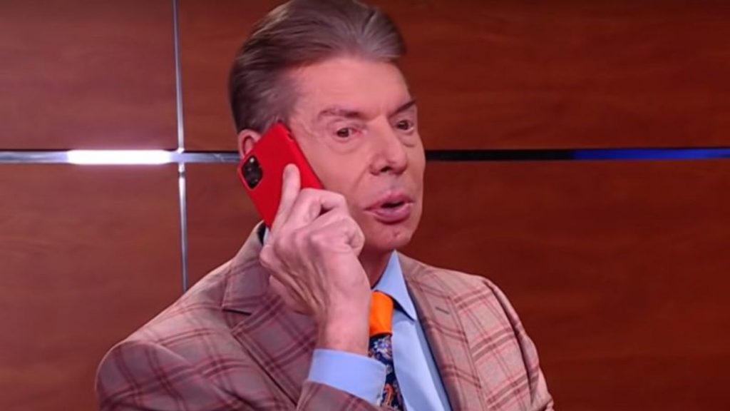 Former WWE chairman Vince McMahon holding a cell phone