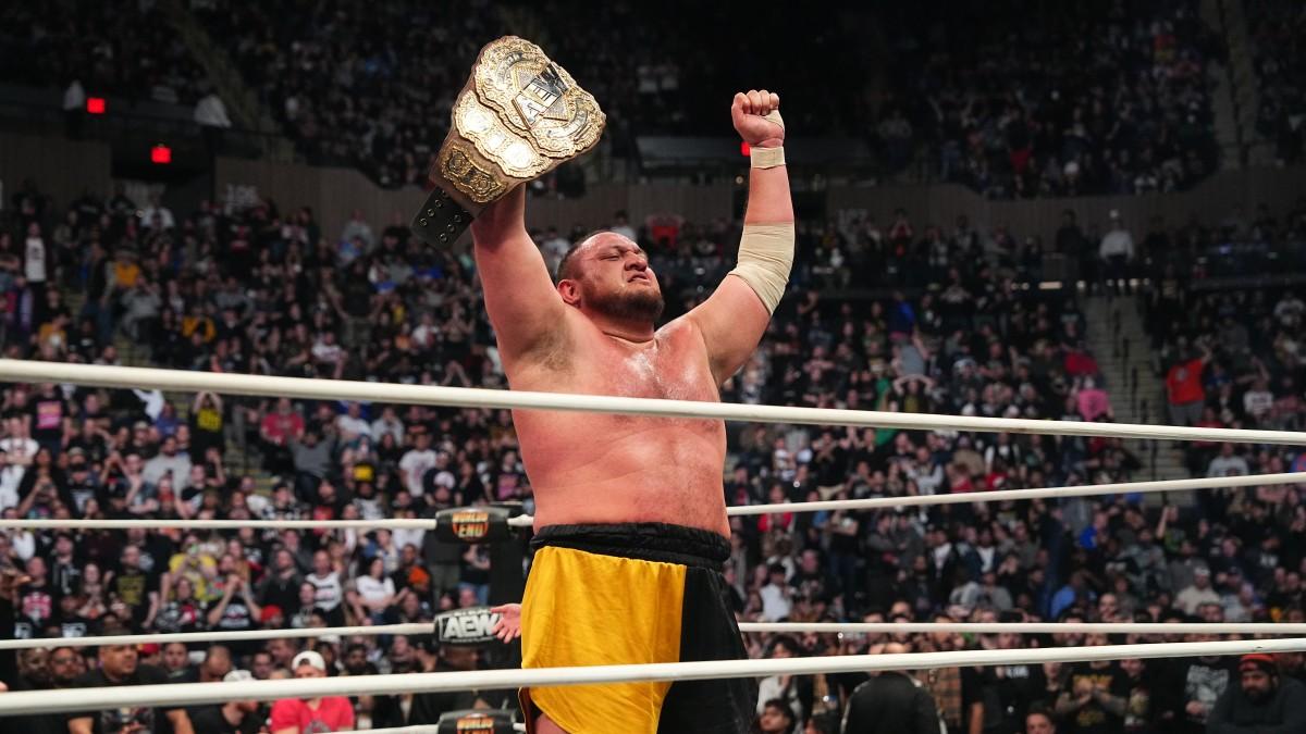 Samoa Joe holding up AEW World Championship in ring after victory