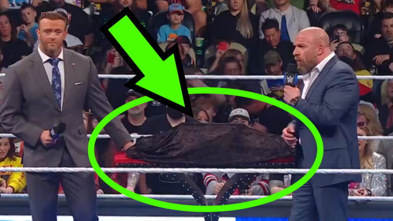 WWE SmackDown shot of Triple H and Nick Aldis with the covered new title belts circled in green