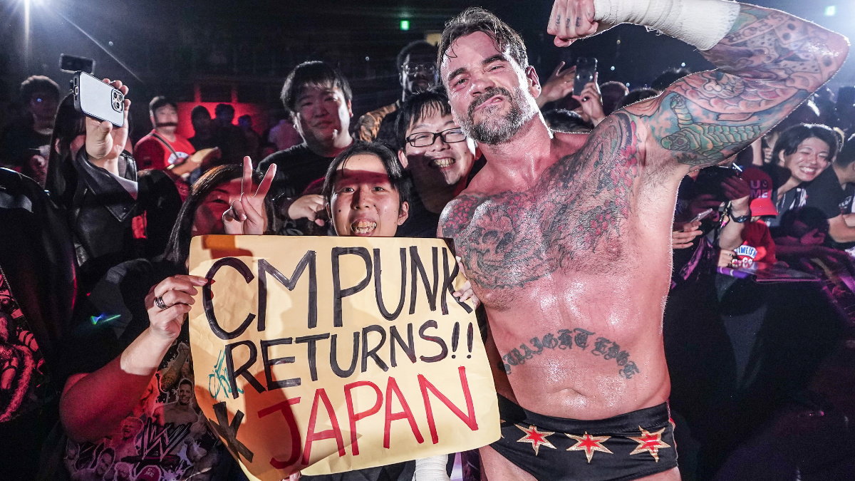 WWE star CM Punk with a "CM Punk returns to Japan" sign